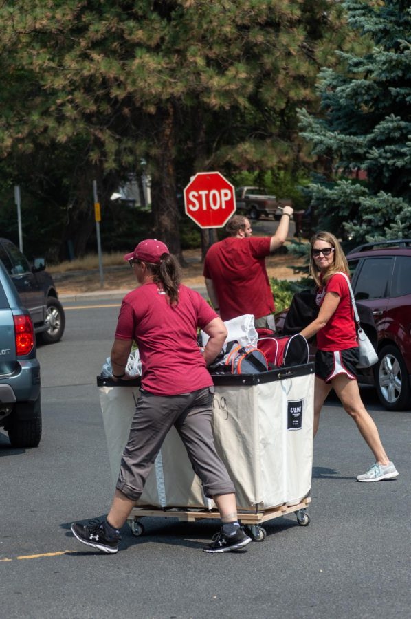 Coug mom Carey Gibbons (right) helps move her son Andrew’s belongings into his new dorm room in Streit Hall with the assistance of Kelli Brown (left).