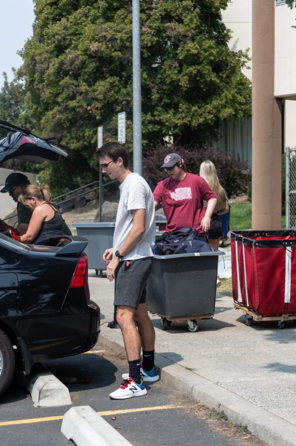Sophomore Jacob Lewis (center) and his parents (left) moving his belongings to his new dorm room in Scott-Coman Hall.