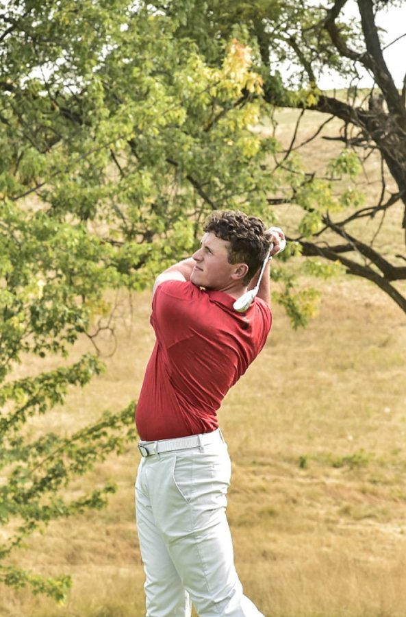 WSU golfer Max Sekulic swings away on a golf course. 