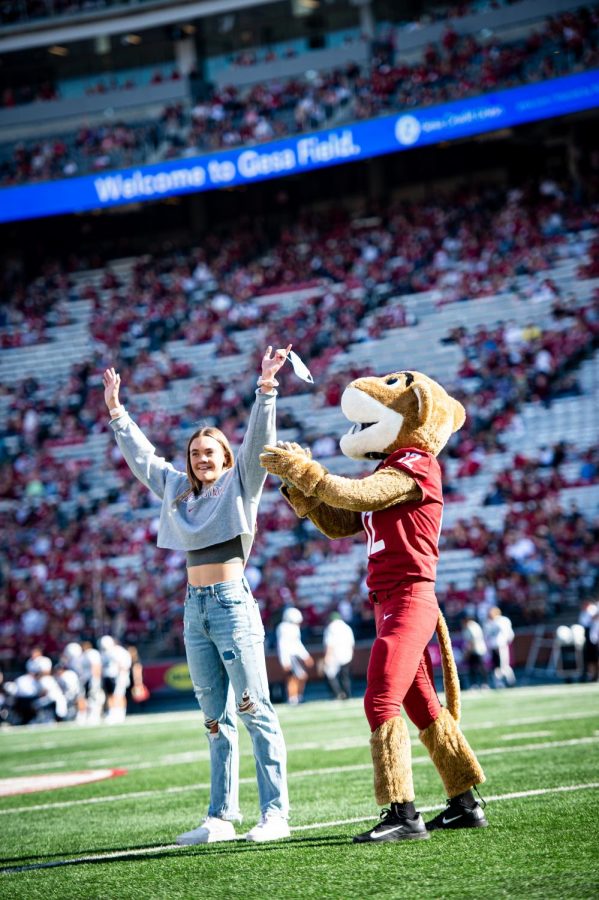 Chloe Larson, Pac-12 50-meter freestyle champion, is recognized on the field alongside Butch T. Cougar during a football game against Martin Stadium on Sept. 11, 2021, in Martin Stadium.