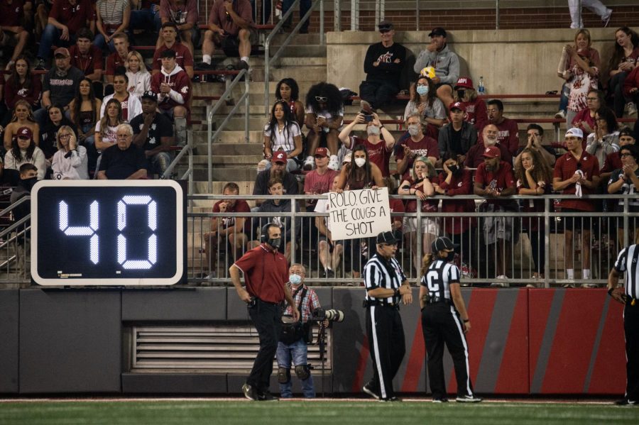 WSU Head Coach Nick Rolovich walks to the sideline as a fan holds a sign at him Sept. 4 at Martin Stadium in Pullman.
