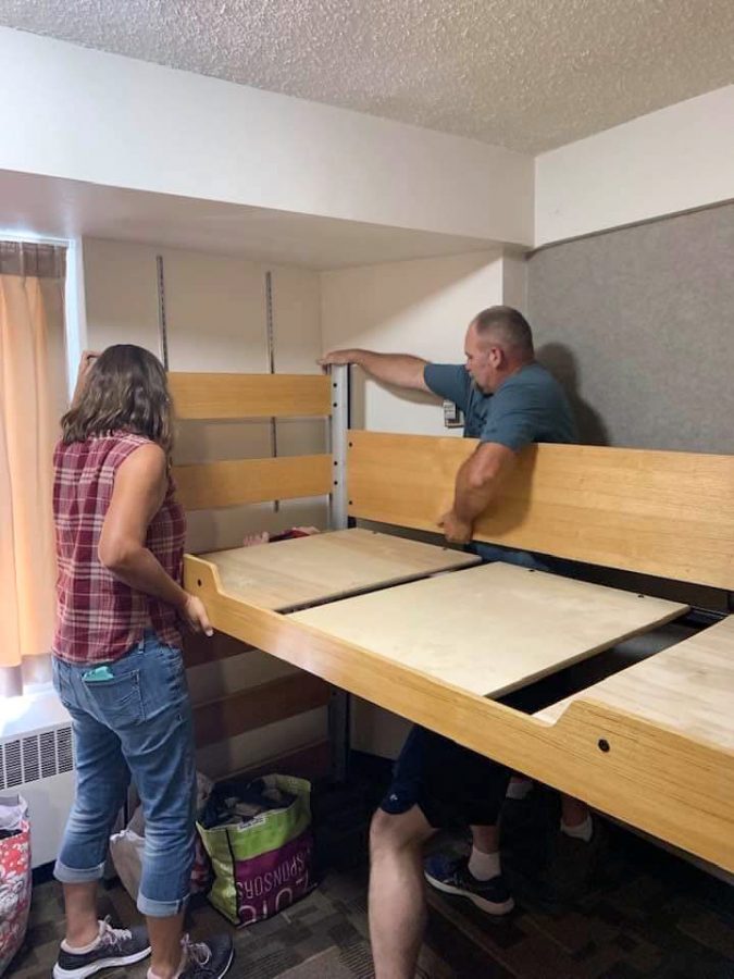 Netta and Dan help set up their daughter Amelias dorm this fall as she moves in. Dan is under the bed lifting the frame, as Netta holds up the side.