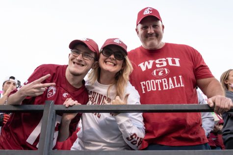 Brenden Potts, Juli Potts and Larry Hall cheer on the Cougars during Family Weekend, Saturday, Oct. 16, 2021, in Pullman, Wash.
