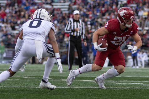 WSU running back Max Borghi (21) evades BYU defensive back Jakob Robinson (0) during the second half of a college football game on Oct. 23, 2021, at Martin Stadium.