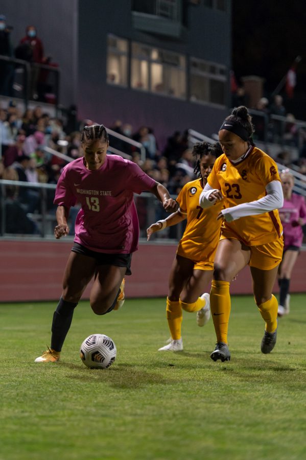 WSU forward Elyse Bennett (13) dribbles past defenders during a college soccer match against USC, Thursday, Oct. 21, 2021, in Pullman.