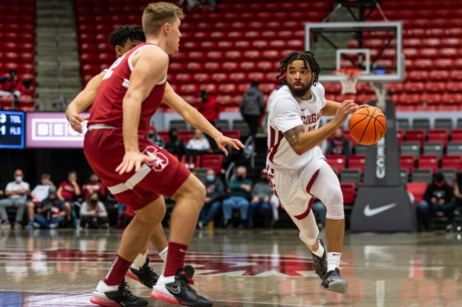 WSU guard Michael Flowers (12) attempts to dribble around Stanford University defenders during the second half of an NCAA college basketball game, Thursday, Jan. 13, in Beasley Coliseum.