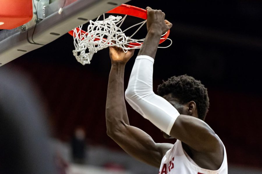 WSU forward Mouhamed Gueye hangs from the rim after dunking the ball during the second half of an NCAA college basketball game against California, Saturday, Jan. 15, in Beasley Coliseum.