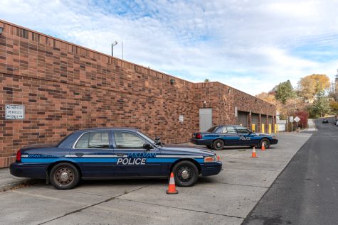 Police cars rest behind the Pullman Police Department, Thursday, Oct. 21, 2021.