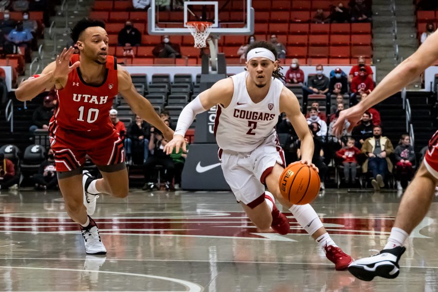 WSU guard Tyrell Roberts (2) dribbles past Utah guard Marco Anthony (10) during the first half of an NCAA collegiate basketball game, Wednesday, Jan. 26, in Beasley Coliseum.
