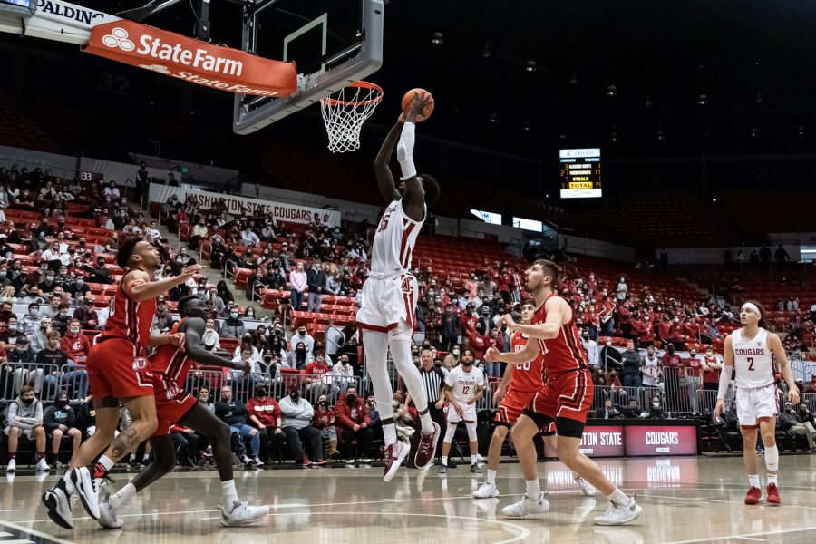 WSU forward Mouhamed Gueye (middle) dunks the ball during the second half of an NCAA collegiate basketball game against Utah, Wednesday, Jan. 26, in Beasley Coliseum.
