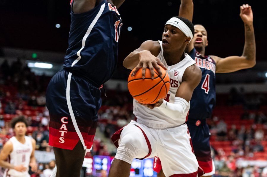 WSU guard Noah Williams (middle) attempts to pass the ball during the first half of an NCAA collegiate basketball game against Arizona, Feb. 10.