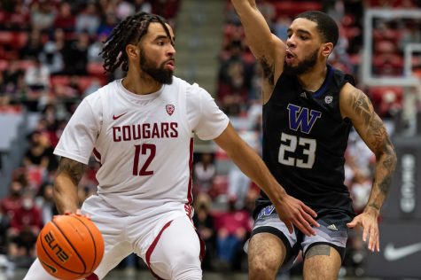 WSU guard Michael Flowers (12) dribbles by UW guard Terrell Brown Jr. (23) during the second half of an NCAA college basketball game in Beasley Coliseum, Feb. 23.