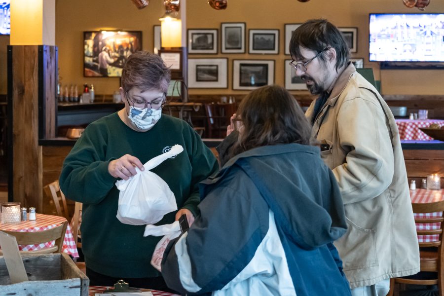 Tahnee Runions, volunteer for Feeding our Friends, hands free meals to Pullman residents Dale Henthorn and Breeanna Nelson, Oak Pullman, Feb. 22