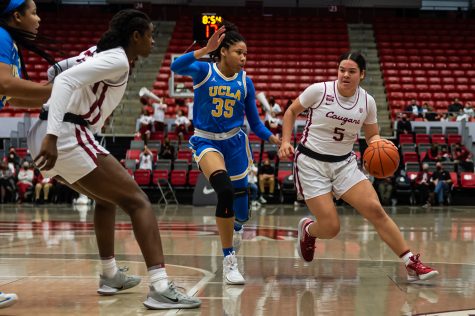 WSU guard Charlisse Leger-Walker (5) dribbles around UCLA guard Camryn Brown (35) during the second half of an NCAA collegiate basketball game, Feb. 11. 2022
