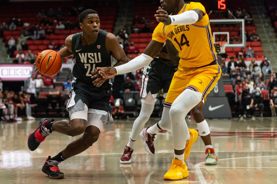 WSU guard Noah Williams (24) dribbles around Arizona State center Enoch Boakye (14) during the second half of an NCAA collegiate basketball game in Beasley Coliseum, Feb. 12.