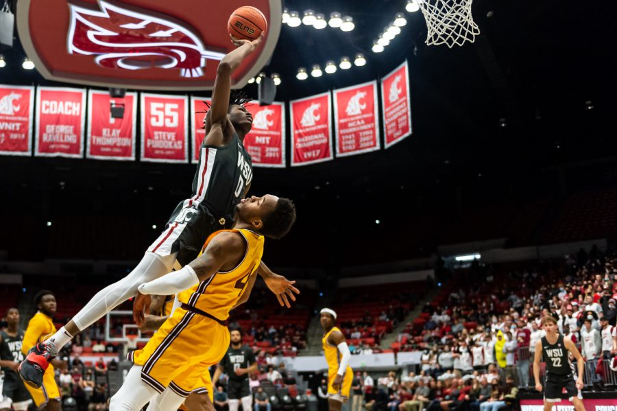 WSU forward Efe Abogidi (0) jumps for a dunk over an Arizona State defender during the first half of an NCAA collegiate basketball game in Beasley Coliseum, Feb. 12.