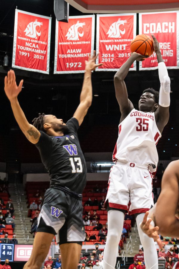 WSU forward Mouhamed Gueye (35) shoots over UW forward Langston Wilson (13) during the second half of an NCAA college basketball game in Beasley Coliseum, Feb. 23.
