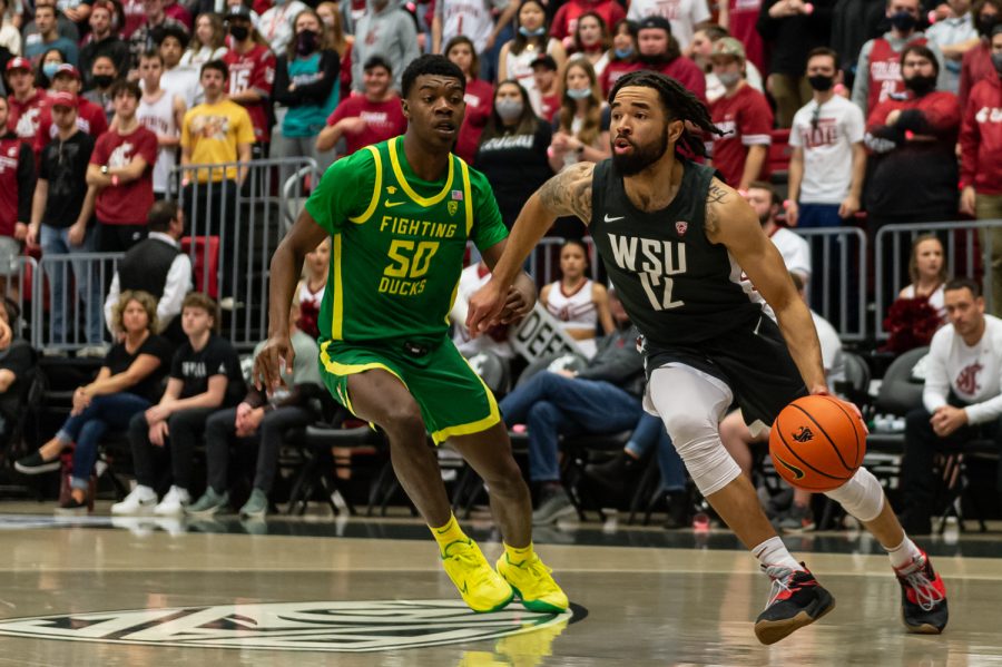 WSU guard Michael Flowers (12) dribbles past Oregon forward Eric Williams Jr. (50) during the first half of an NCAA college basketball game in Beasley Coliseum, March 5.