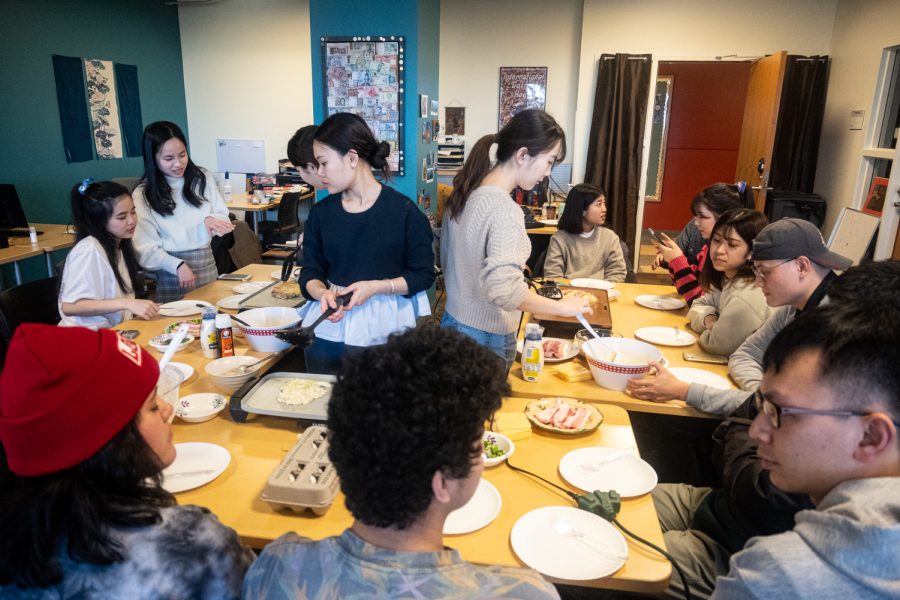 Students at the International Center, located in the CUB, gather around to cook and eat okonomiyaki, a traditional Japanese dish, as part of a series on cooking demos, April 5.