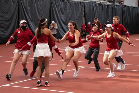 The WSU womens tennis team celebrates Fifa Kumhoms win during an NCAA collegiate tennis match against UW, April 15.