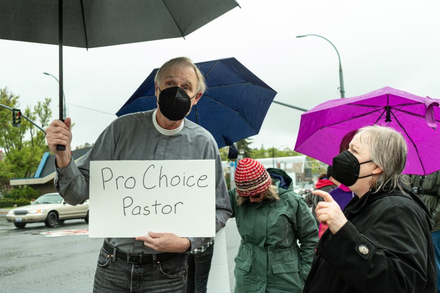 Pastor Steve Vankuiken speaks with organizer Diana Whitney as he holds his pro-choice poster at the Womens March Foundations Bans Off Our Bodies rally, May 14.