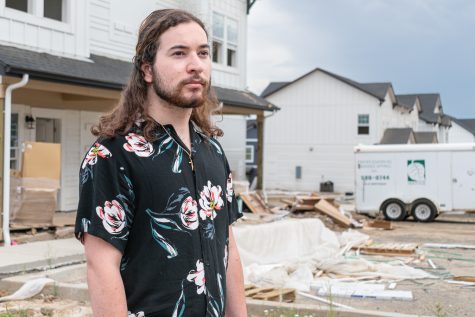 Damien Sarrazolla, senior Spanish major, stands in front of Aspen Heights unfinished apartment complex, Aug. 10. 