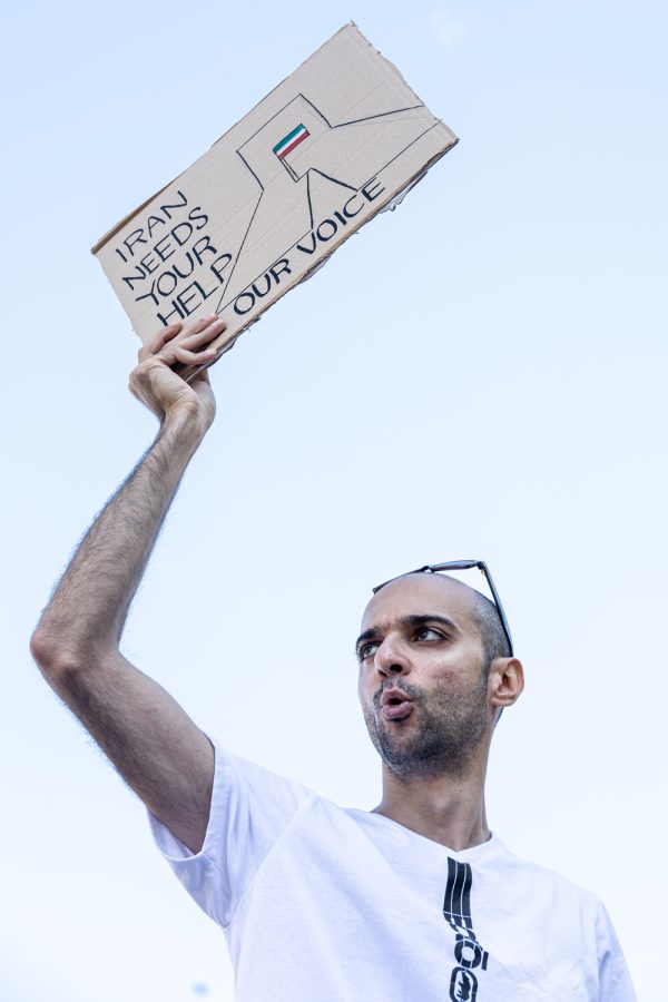 Amir Moadab pictured holding a sign that says, Iran needs your help, Sept. 27. 