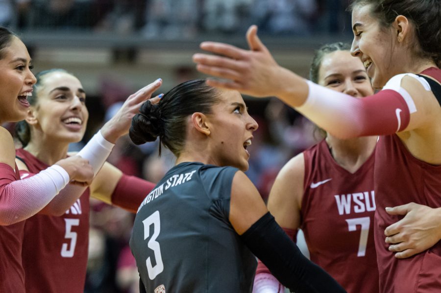 WSU libero Karly Basham celebrates with her teammates after scoring a point during an NCAA volleyball match against UW, Nov. 25.