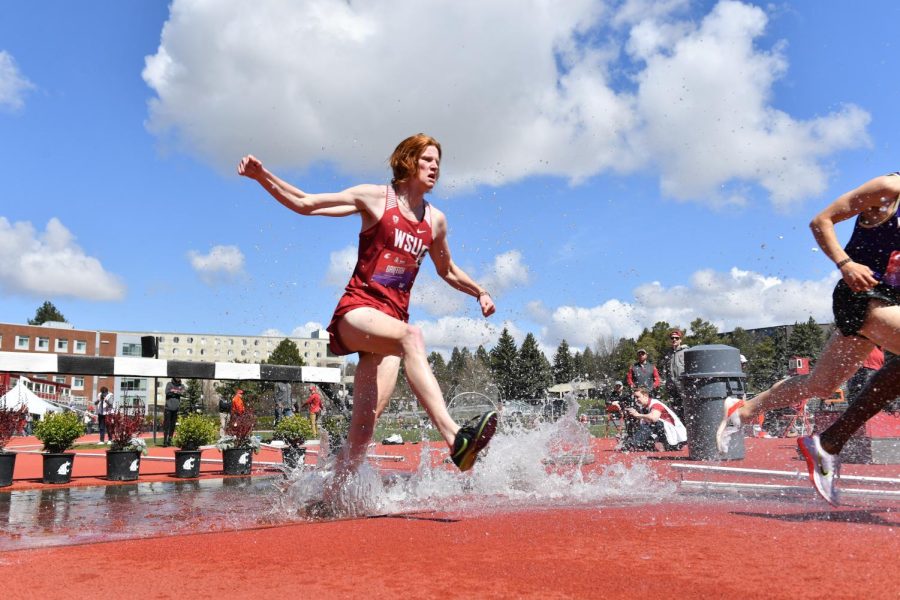 Sam Griffith running through a water ditch during a steeplechase event