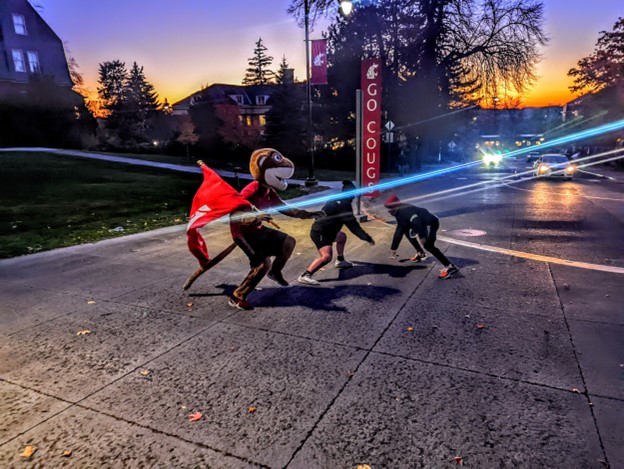 Butch attempts to save a runner from a hunter in front of the Chinook Bus stop, in a game of Fugitive, put on by sports management seniors for their capstone project in support of the the Alzheimers Association, Nov. 9.