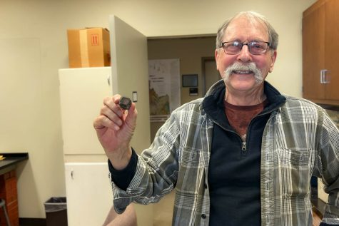 WSU geology professor Peter Larson holds an unpolished star garnet from Idaho.