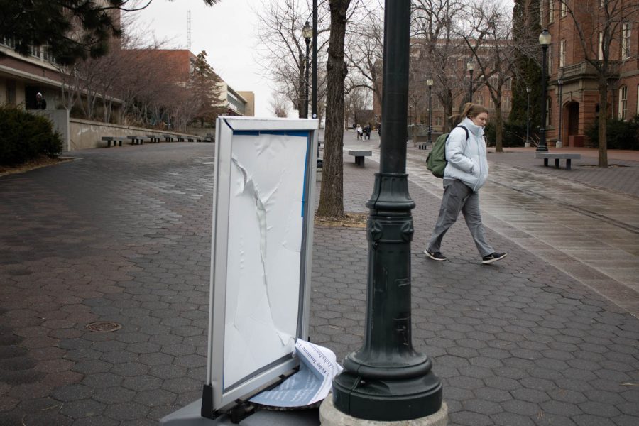 The fast paced winds mixed with the sideways snow forced a sign on Terrell mall to fall apart on Feb 21. A student walks by in winter clothes.