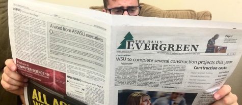 Man reading student newspaper