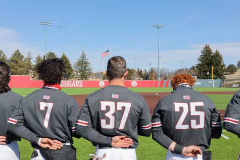 Cam Magee (left), Nate Swarts (center) and Sam Brown (right) stand along the third base line during the playing of the national anthem prior to WSU baseballs second game against the Oregon Ducks, March 18, 2023 at Bailey-Brayton Field.