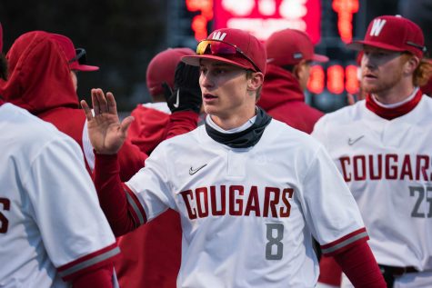 WSU infielder Elijah Hainline high-fives his teammates after winning an NCAA baseball game against Southern Indiana, Saturday, March 4, 2023, in Pullman, Wash.