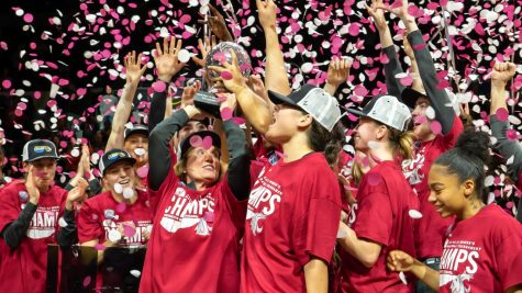 WSU head coach Kamie Ethrige hoists the Pac-12 Championship trophy as her WSU womens basketball team celebrates after beating UCLA 65-61 in the Pac-12 Championship, March 5, 2023 in the Michelob ULTRA Arena in Las Vegas.