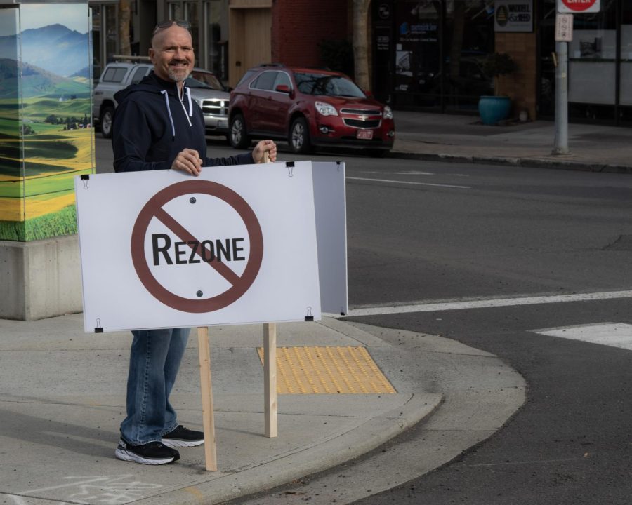 A protestor holds signs rejecting the biodiesel plant rezoning, Pullman, Wash. April 10th.