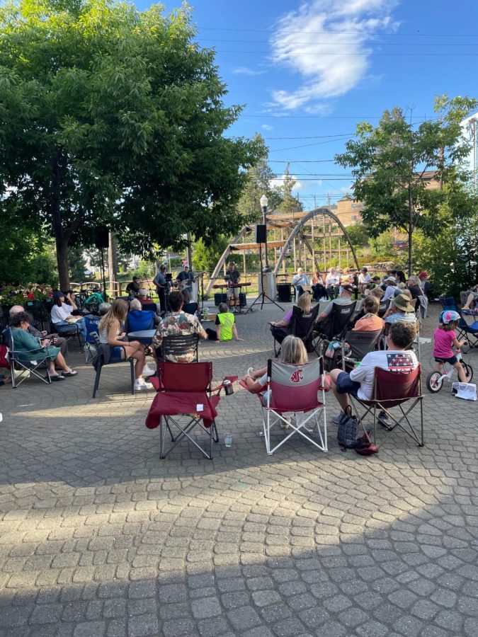 People sitting in downtown Pullman enjoying the music at Music on Main