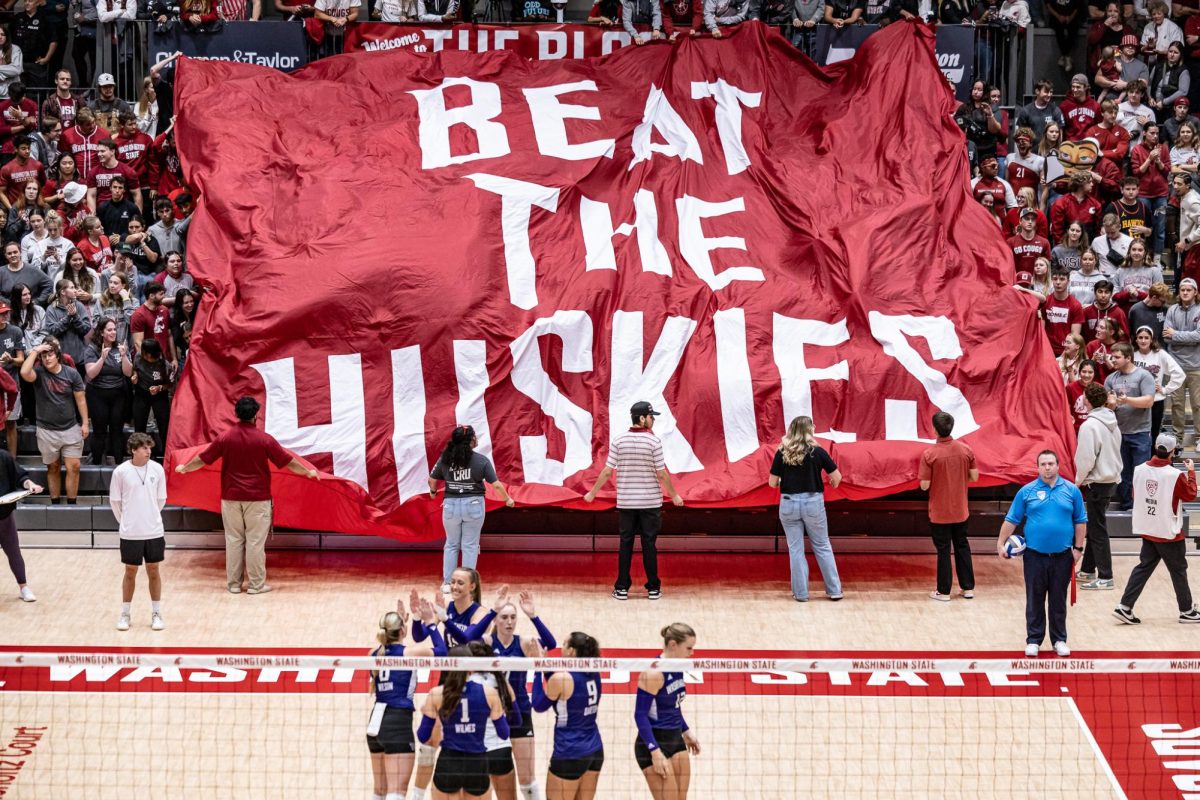 WSU students hold up a banner reading “Beat The Huskies” before an NCAA volleyball match against UW, Sept. 21, 2023, in Pullman, Wash.