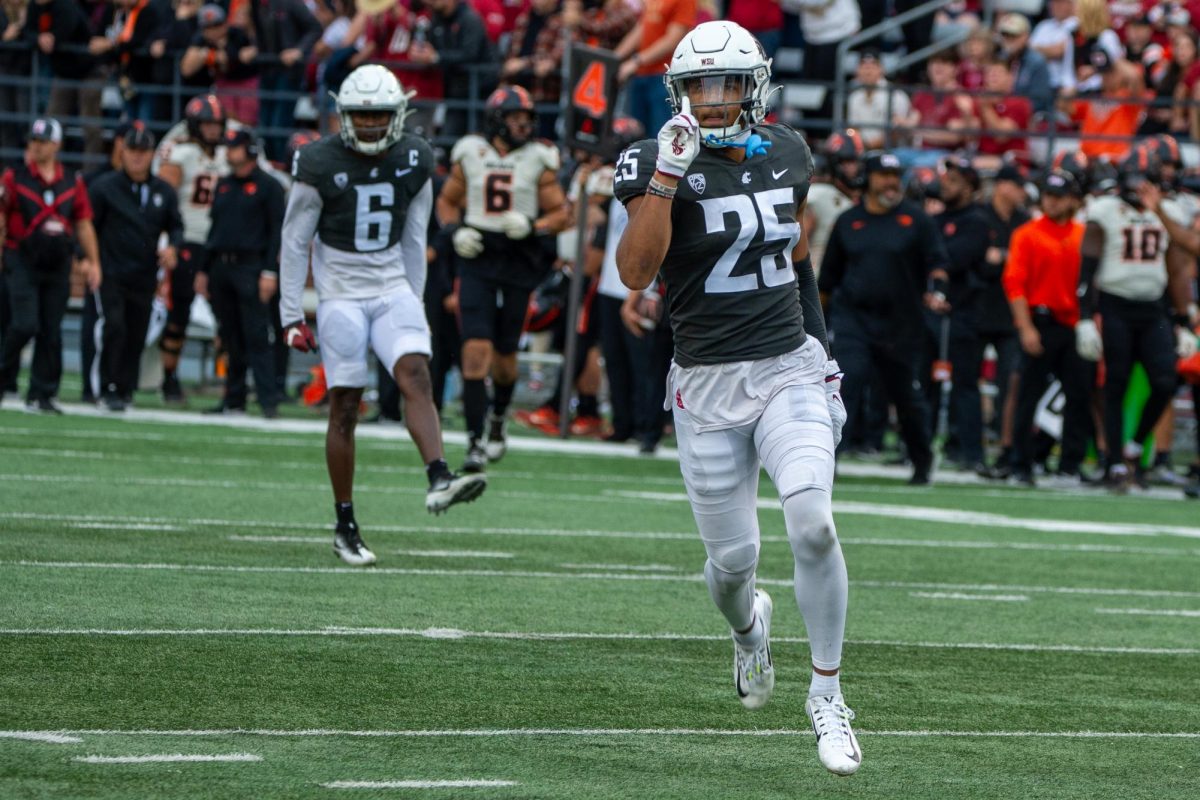 Jaden Hicks shakes his hand toward his sideline while Chau Smith-Wade celebrates behind him, Sept. 23, in Pullman, Wash. 