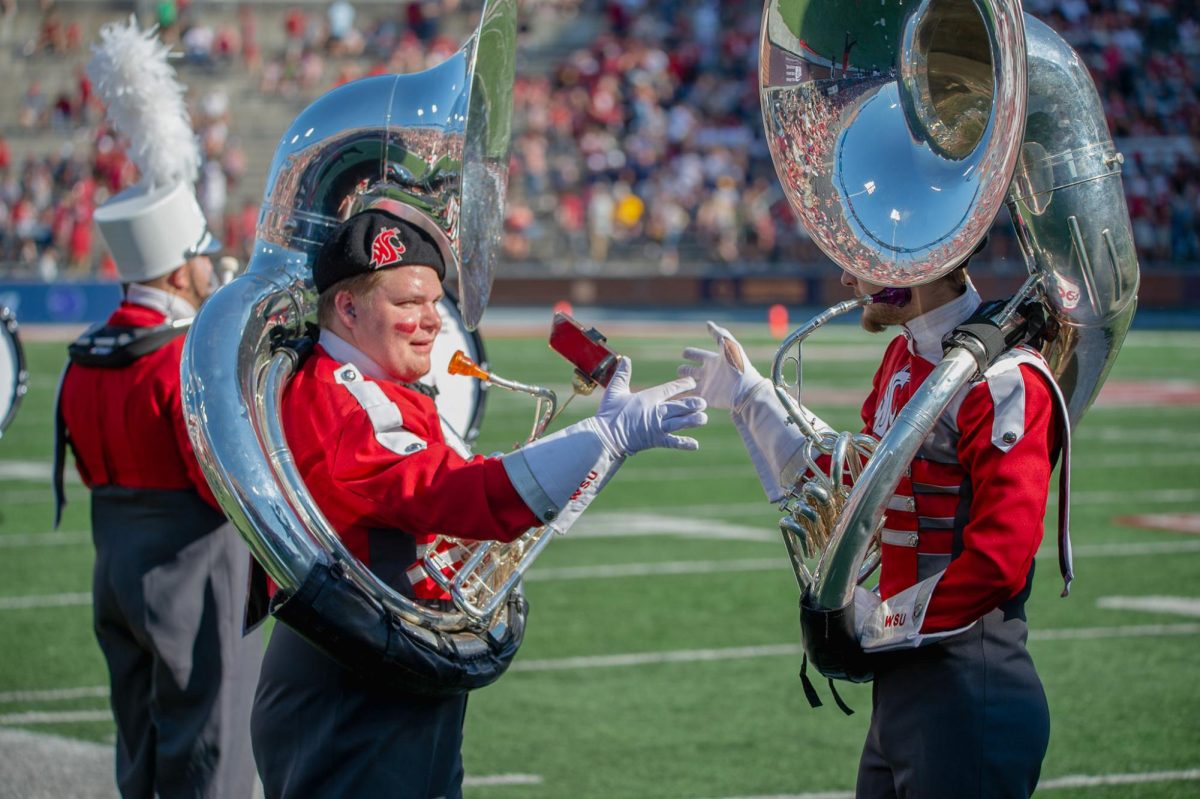 Two marching band members do a pregame high five before taking the field to perform against Northern Colorado, Sept. 16. 