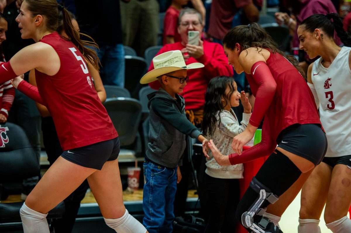 Jasmine Martin high fives a young fan after winning match in Bohler Gym, Oct. 6, in Pullman, Wash. 