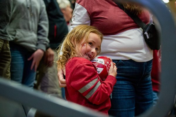 A young WSU fan smiles with a ball after getting it from a Coug volleyball player pregame of an NCAA volleyball match, Oct. 13, in Pullman, Wash. 
