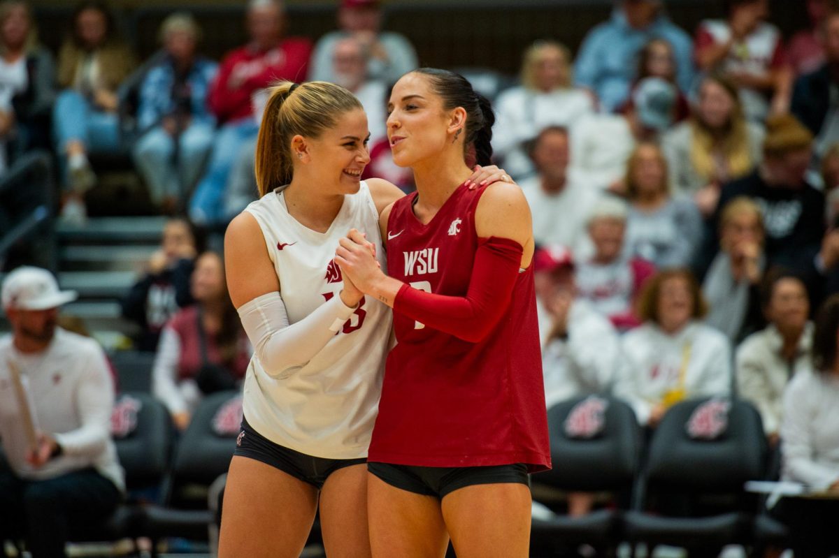 Emma Barbero (left) and Karly Basham (right) laugh as they get ready to play a point vs Utah in an NCAA volleyball match, Oct. 13, in Pullman, Wash. 
