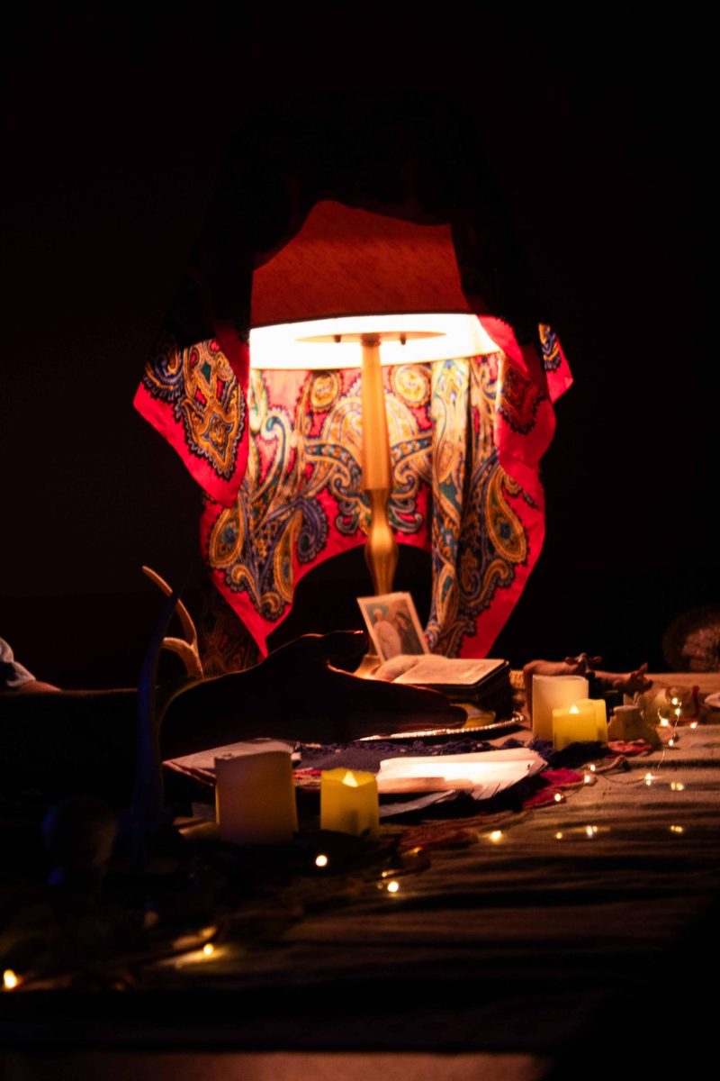 Laurie, a tarot reader, discusses the tarot reading process at a secluded, dimly lit table. 