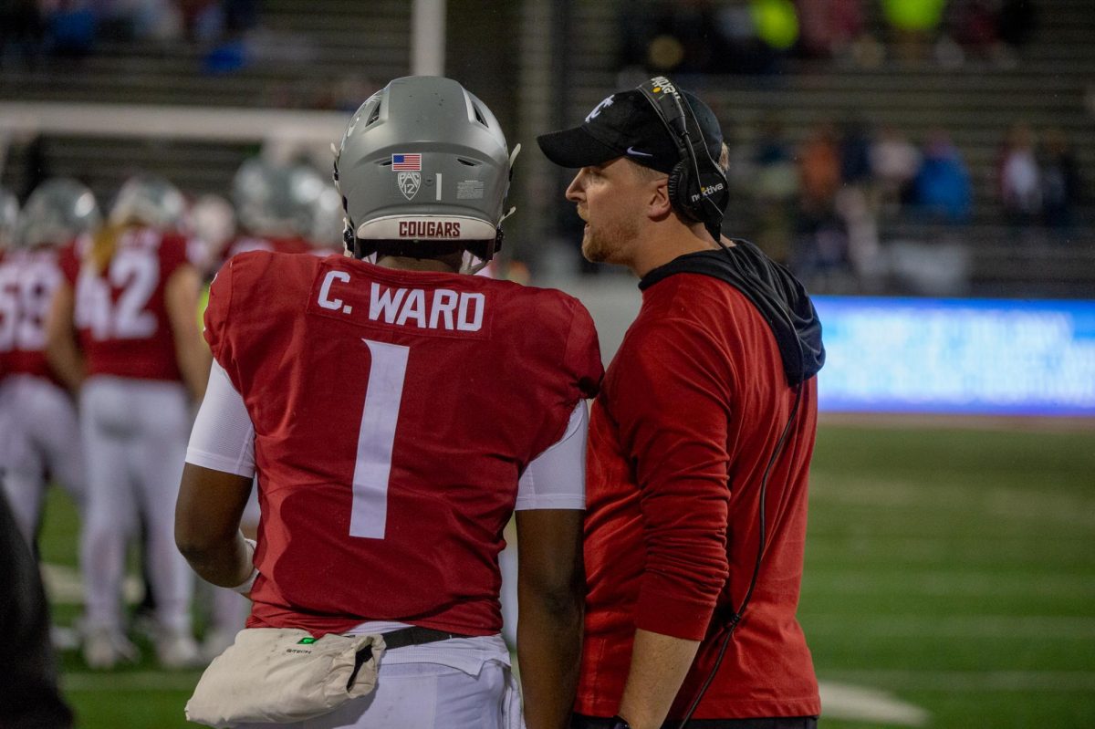 Cam Ward talks with offensive coordinator Ben Arbuckle before taking the field, Nov. 4, in Pullman, Wash. 