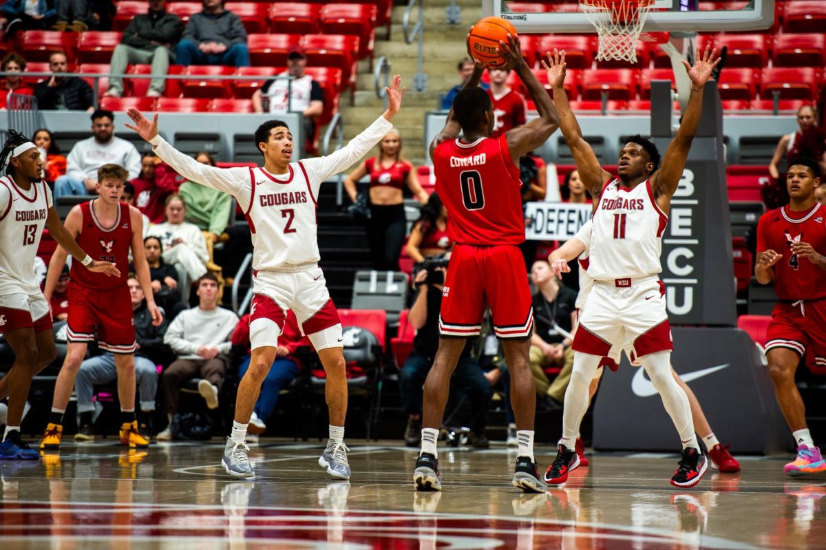 Myles Rice and Joseph Yesufu double-team EWU's Cedric Coward at the top of the arc, Nov. 27, in Pullman, Wash. 