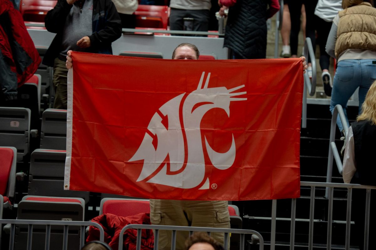 A WSU fan holds up the flag after the womens basketball win over Gonzaga, Nov. 9, in Pullman, Wash. 