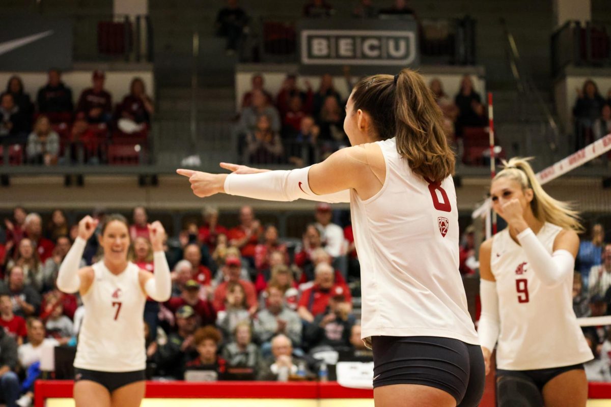 Katy Ryan points to her teammates after they score a point in a match against USC, Nov. 12, in Pullman, Wash.