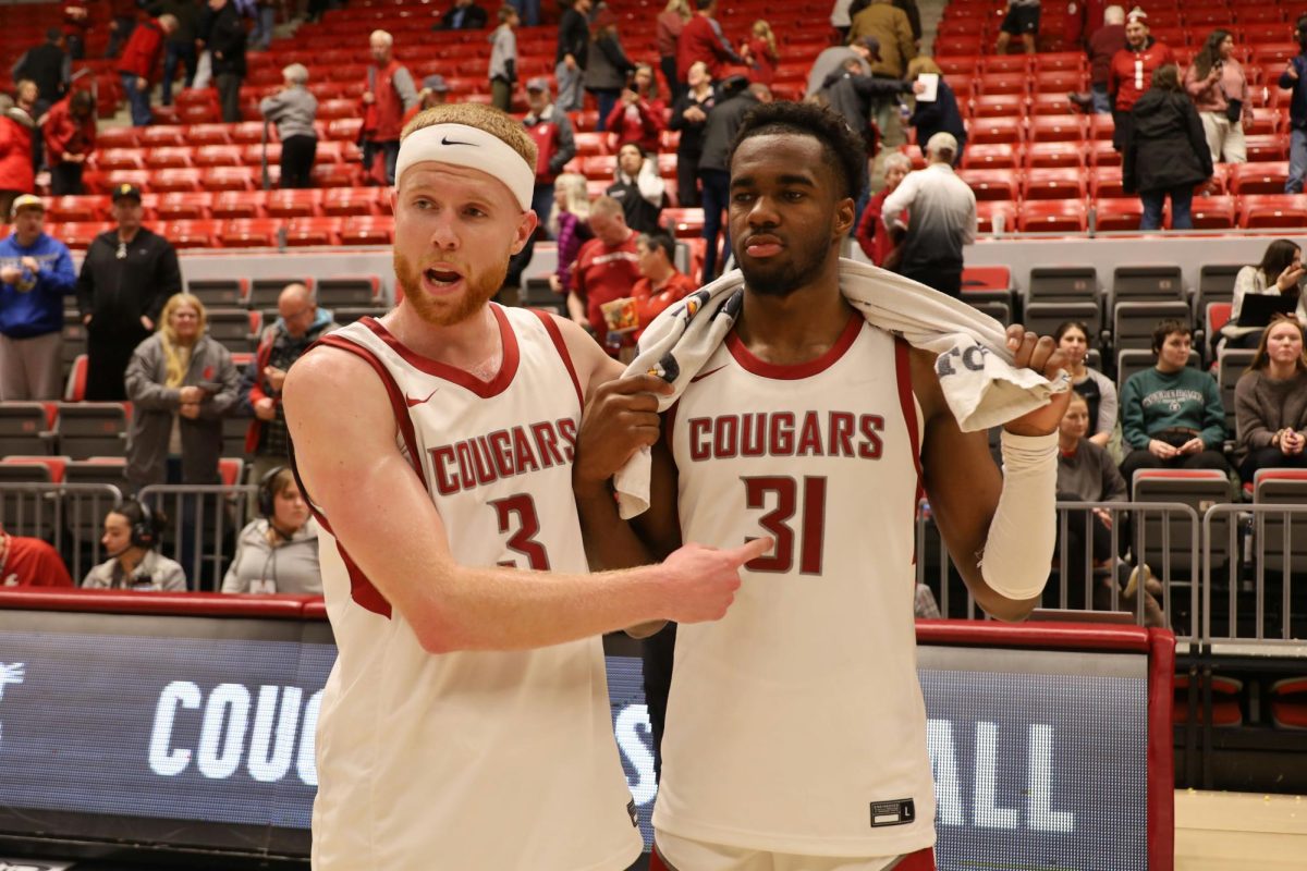 Jabe Mullins lauding Kymany Houinsou after an NCAA basketball game, Dec. 10
